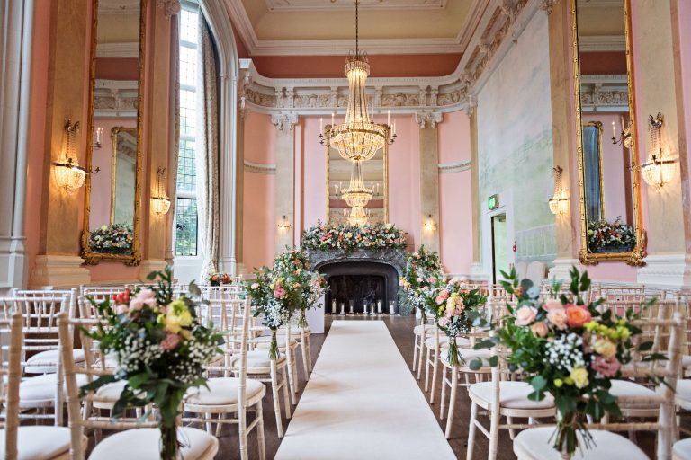 Interior photograph of a luxurious wedding ceremony room at Danesfield House. Chandelier's and ornate fixings and large mirrors make this truly special.