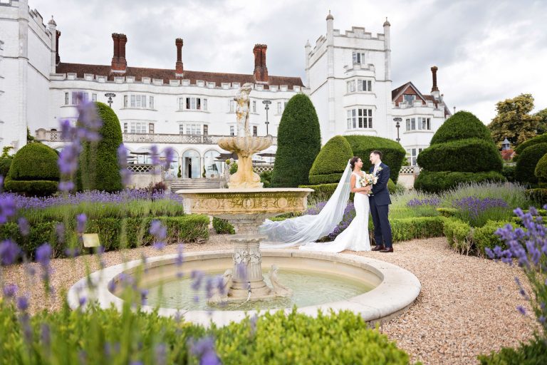 Bride and groom stand in the impressive grounds at Danesfield House.