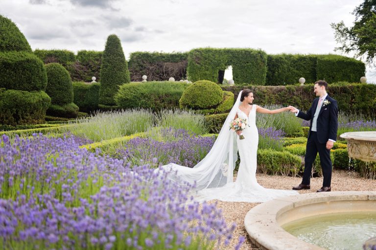 Bride and groom stand in the impressive grounds at Danesfield House. Lavender everywhere.
