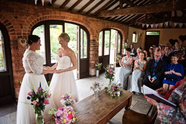 Wedding taking place at Dodmoor House. Family and friends look onward at the bride and bride getting married.