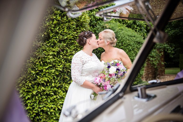 Bride and bride kiss, photographed through a split screen VW.