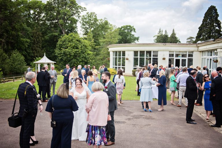 Outdoor scene of wedding guest chatting and smiling at Double Tree Hilton