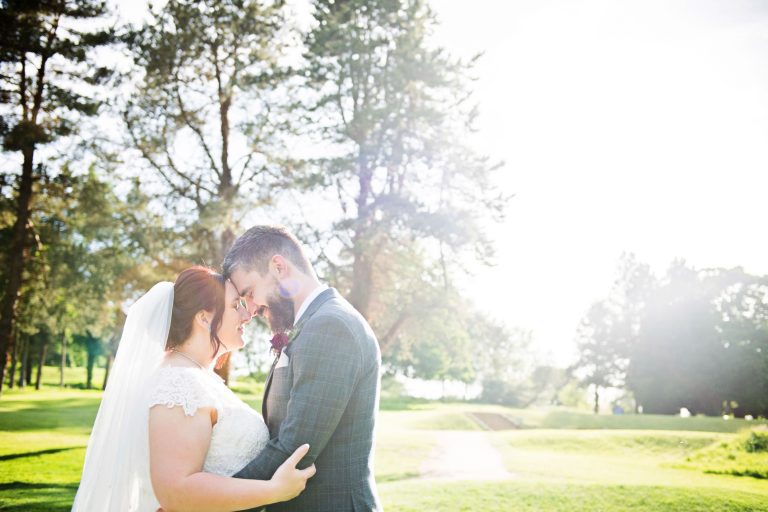 Bride and groom with their heads together catch a moment together.