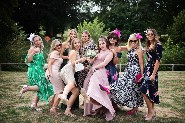 Bunch of ladies posing for the camera at a wedding.
