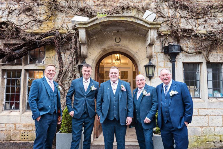 Groom and his groomsmen stand, hands in pockets before the wedding at Hatton Court Hotel.