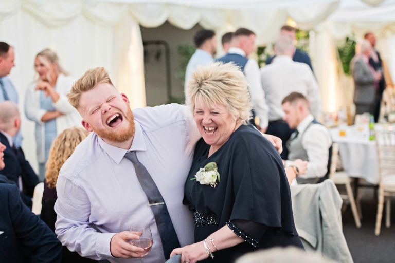 Documentary photo of wedding guests laughing.