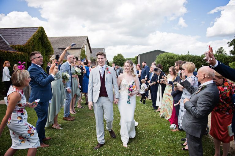 Bride and groom walk through the confetti isle