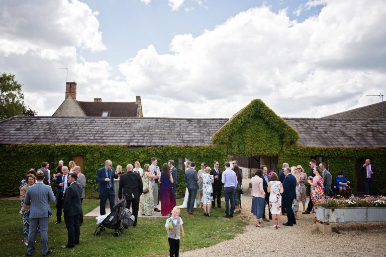 Outdoor scene of wedding guests enjoying themselves in the grounds of Huntsmill Farm during the wedding reception.