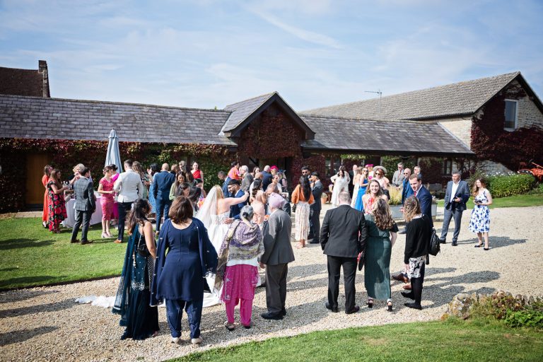 Outdoor scene of wedding guests enjoying themselves in the grounds of Huntsmill Farm during the wedding reception.