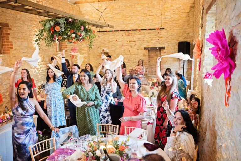 Fun photo of wedding guest waving their napkins as the bride and groom (not in picture) enter the wedding breakfast.