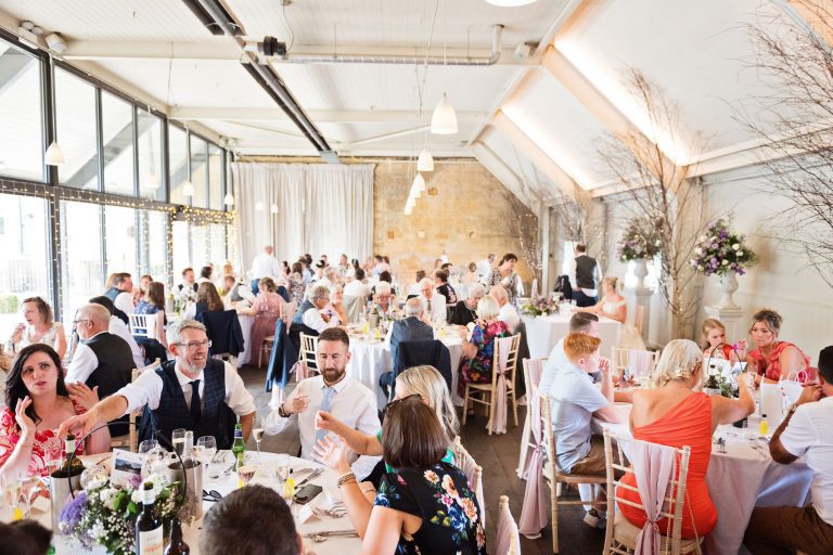 Overview of the wedding breakfast at Lapstone Barn. Guests enjoying themselves.