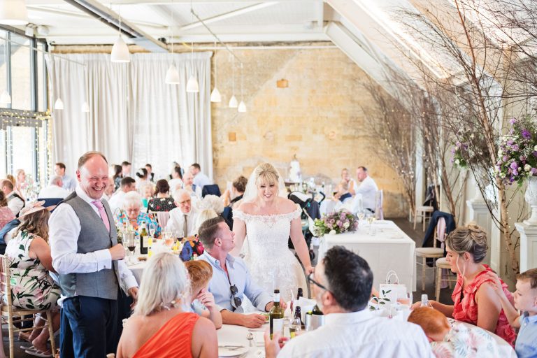 Bride and groom working the room in the wedding breakfast by talking to their wedding guests.