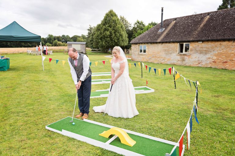 Fun photo of the bride and groom playing pitch and put golf.