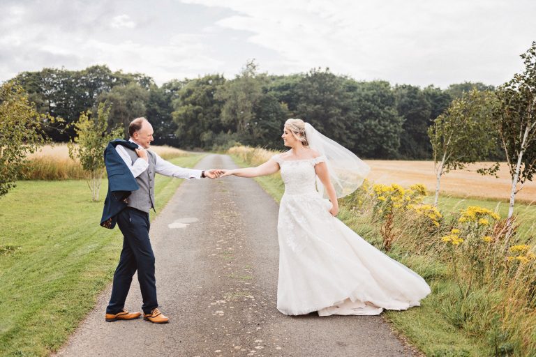 Bride and groom practice their first dance on the country road at Lapstone.