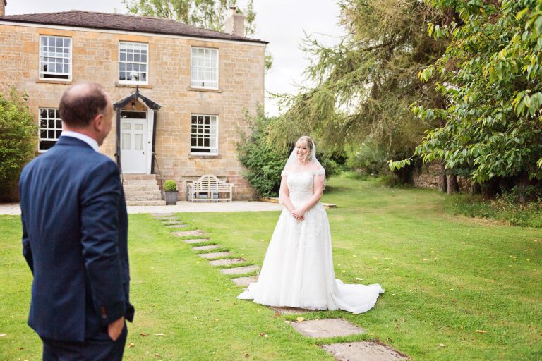 Bride and groom look at each other in the grounds at Lapstone.