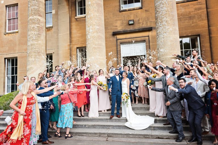 On the grand steps of Leigh Court as the bride and groom get showered in confetti.