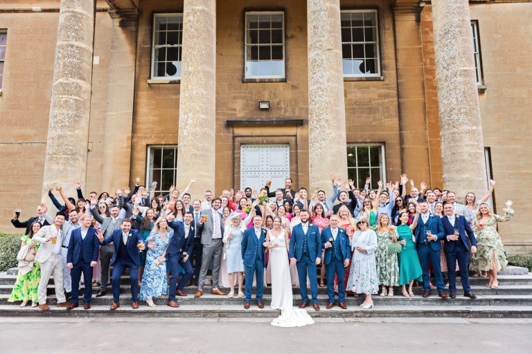 Large group wedding shot on the steps, outside the front of Leigh Court.