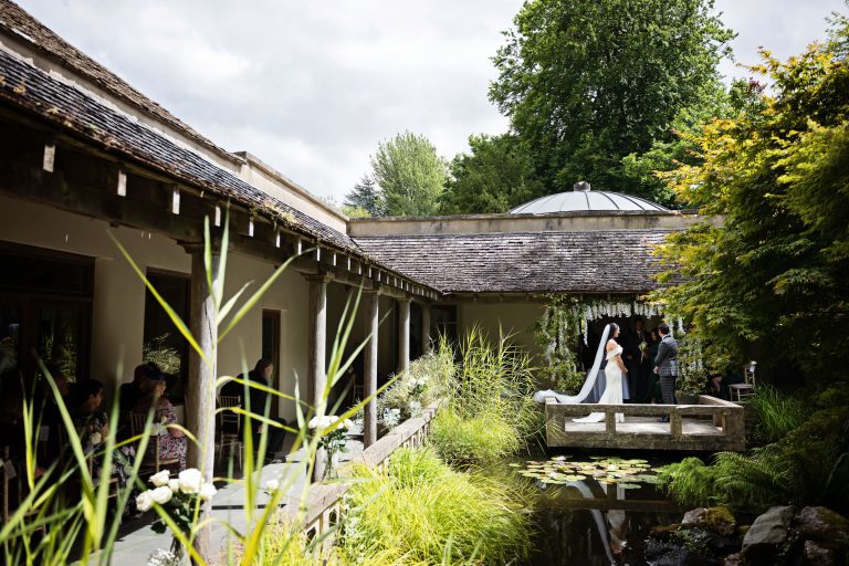 Bride & Groom stand together for their wedding ceremony in the Cloistered Courtyard.