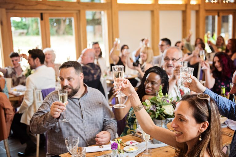 Wedding guests raise a glass to the end of the wedding speeches.