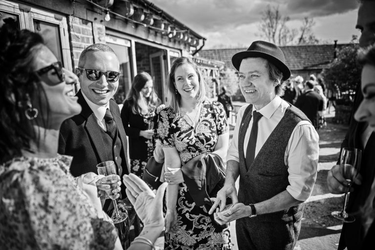 B&W photo of Magician Darren Campbell wowing wedding guests with his tricks.