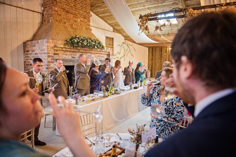 Wedding speeches ending with people raising a glass and celebrating.