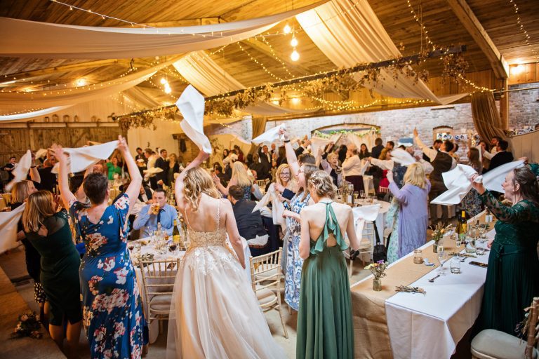 Wedding guests raising their napkins in the air as the wedding party is starting to kick off.