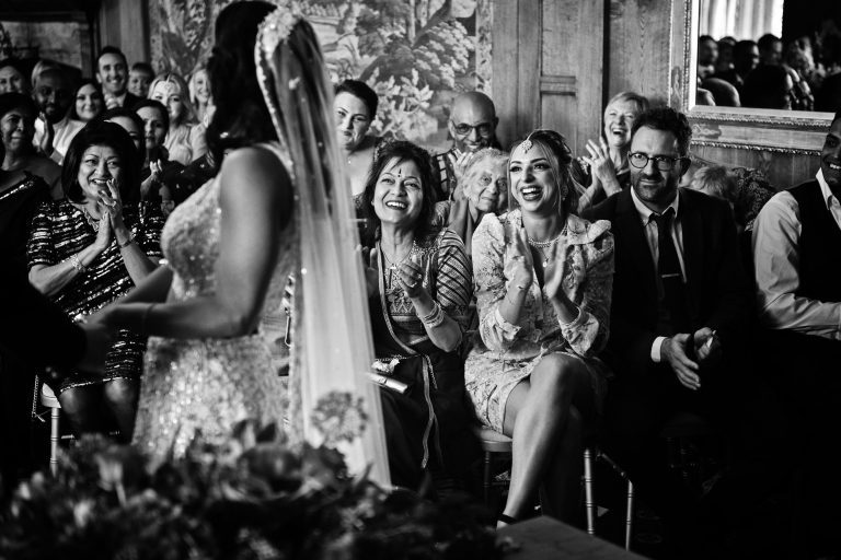 B&W photo of team bride (family) smiling, clapping and congratulating the bride.
