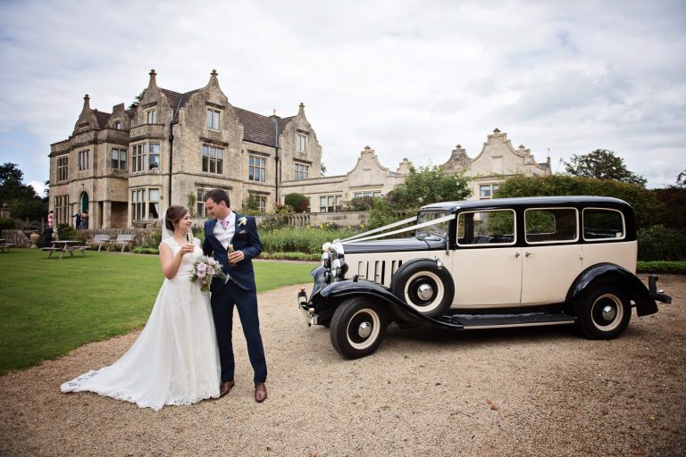 Bride and groom stand in front of Old Down Manor.