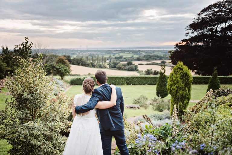Bride and groom with their back to the camera as they grab a moment together.