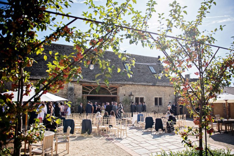 Wedding guests mingle outside Oxleaze Barn.