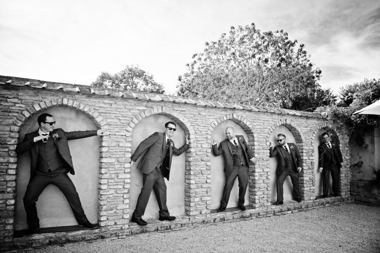 Groomsmen pose in the arched wall. B&W photo.