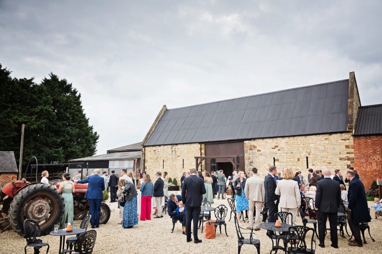 Wedding guests enjoying each others company in the courtyard at Slapton Manor.