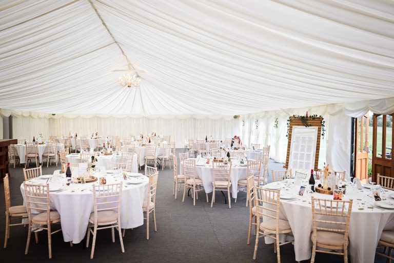 Overview of the wedding breakfast layout in the marquee at Slapton Manor.