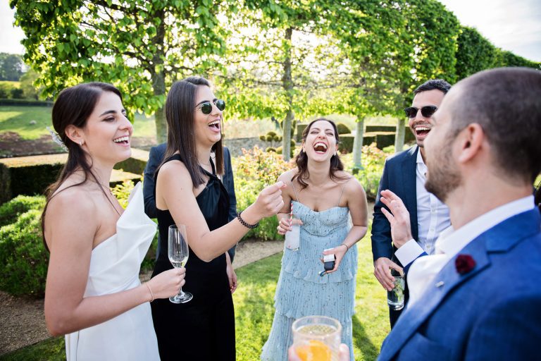Candid photo of bride and her friends chatting and laughing n the gardens.