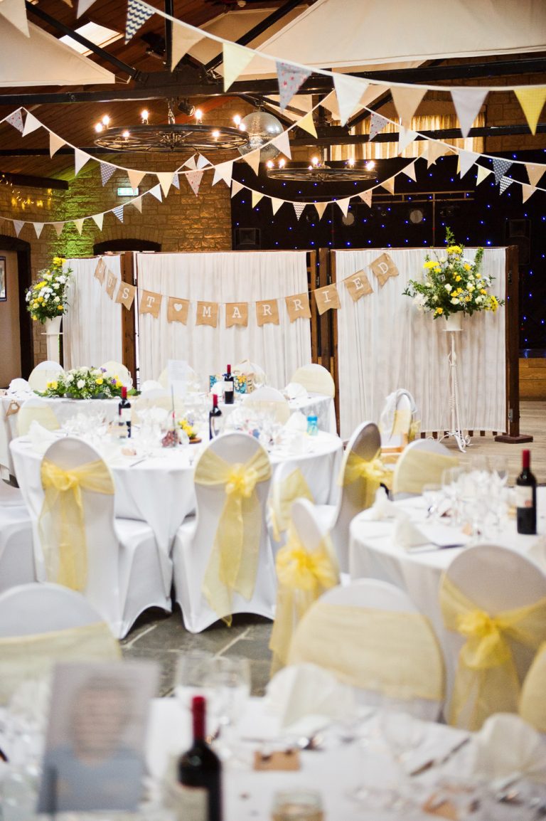 Portrait photograph of the barn set up for a wedding breakfast.