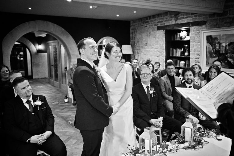 B&W documentary photo of bride and groom during the wedding ceremony.