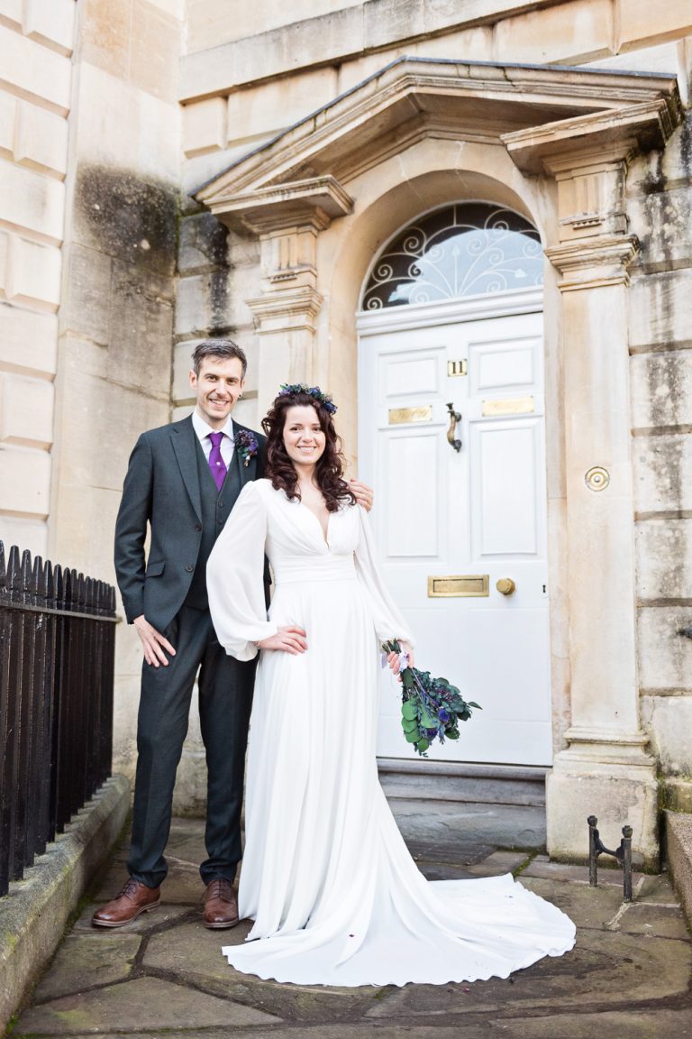 Portrait photo of bride and groom standing in front of a grand Georgian door in Bristol.