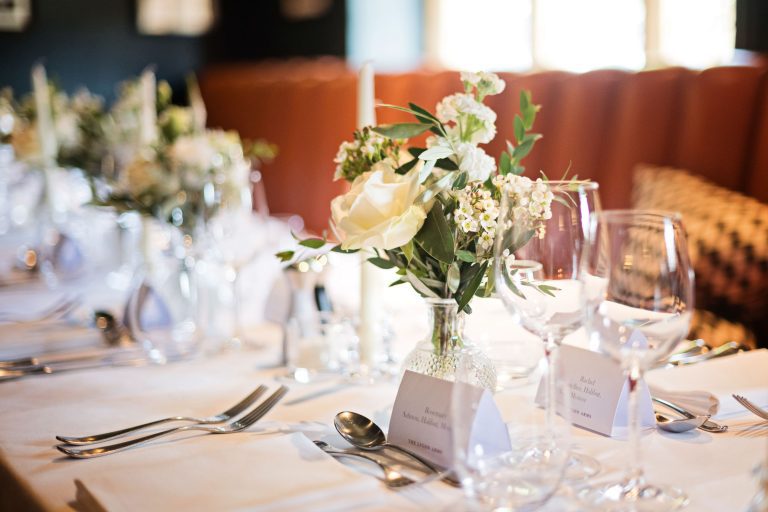 Wedding breakfast set up. Candles lit and flowers and wine glasses.