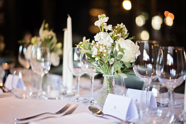 Wedding breakfast set up. Candles lit and flowers and wine glasses.