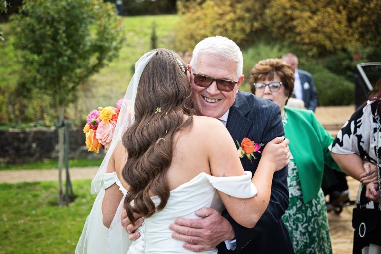 Storytelling candid photo of the bride being congratulated by the father of the groom.