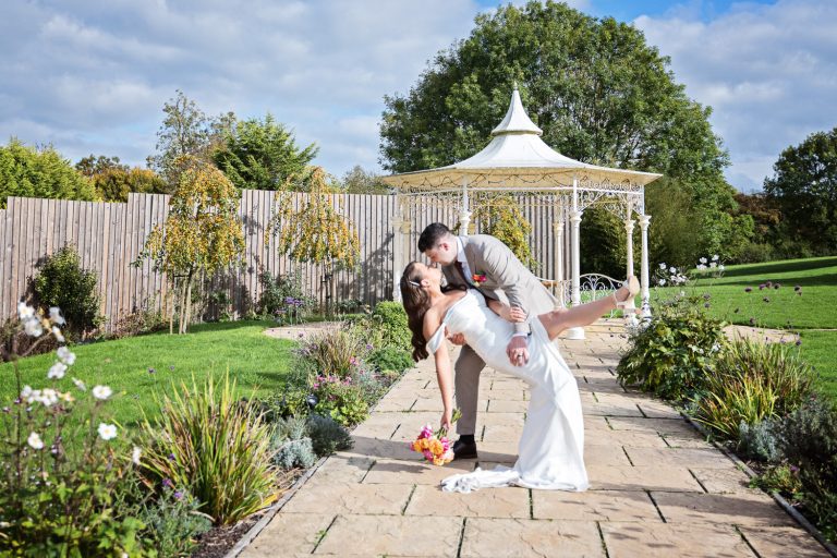 Bride and groom doing a dip in The Pear Tree, Purton. Candid wedding photo for Wiltshire Wedding.