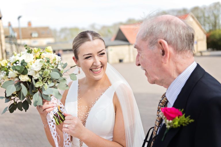 Bride showing off the sentimental details of her flower bouquet.