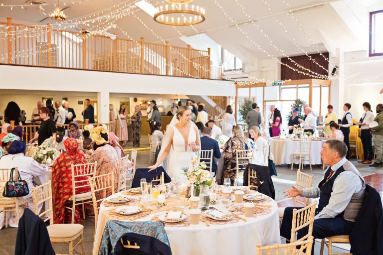 Bride chats to wedding guest as the wedding party goes on at Worton Hall.