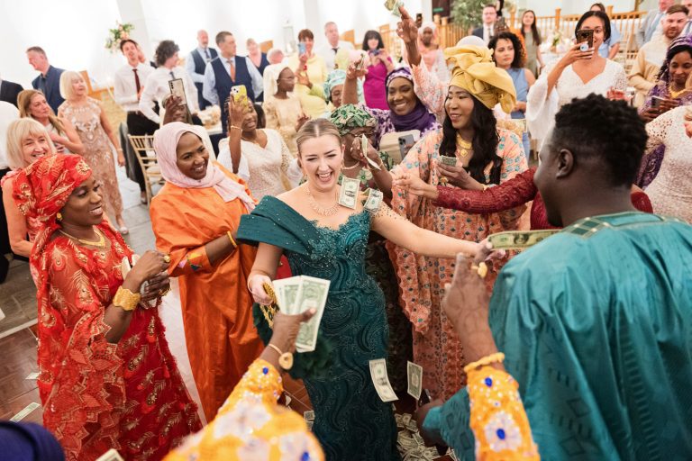 Bride being showered by dollars at a African wedding at Worton Hall.