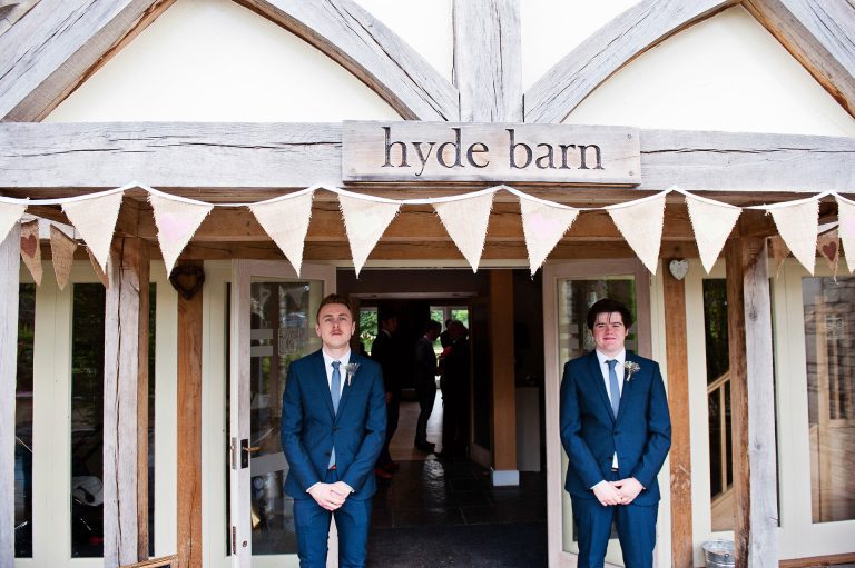 Groomsmen stand at the door of Hyde House like doormen.