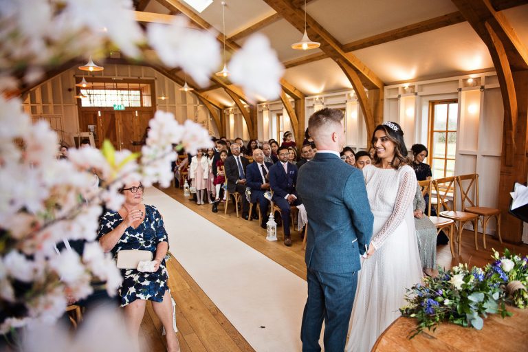 Bride and groom say their wedding vows in front of their wedding guests.