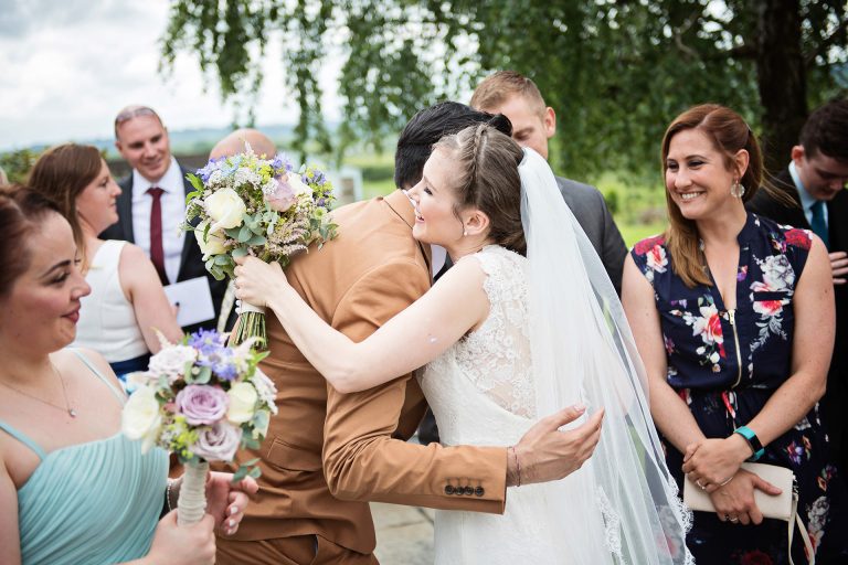 Candid storytelling photo of bride getting congratulated by their wedding guests.