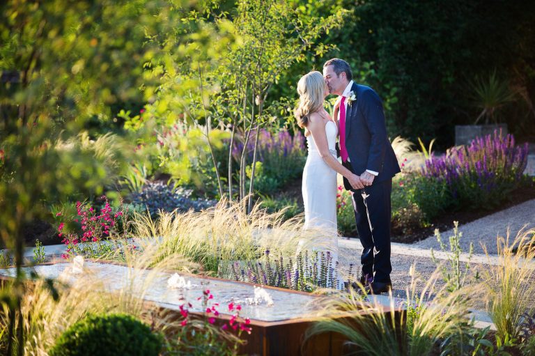 Bride and groom kiss in the gardens at Hyde House.