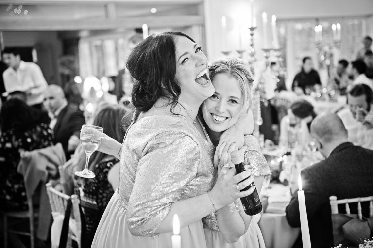 B&W candid photo of wedding guests having fun.