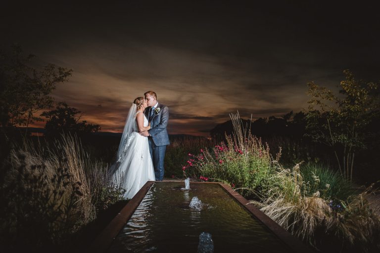 Bride and groom lit up in the gardens at Hyde House.